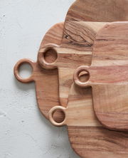 Drei übereinanderliegende Schneidebretter aus Holz mit runden Griffen, von oben betrachtet.