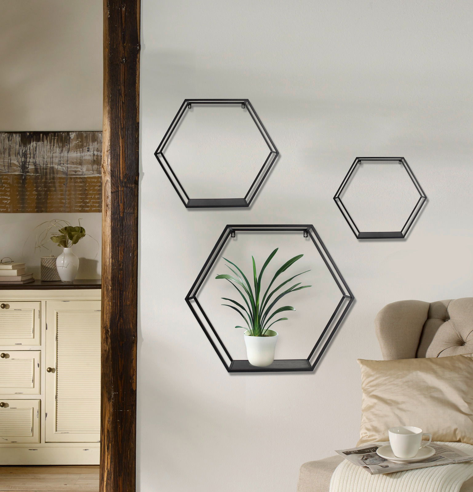 XORA Wandregal 3er Set DANA Dreiteiliges Wandregal-Set in sechseckiger Form, an einer Wohnzimmerwand montiert, mit einer Pflanze in einem der Regale. Perspektive von vorne.