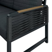 Detailansicht einer Loungegarnitur mit dunklem Stoffbezug und seitlichen Armlehnen aus Holz und geflochtenem Seil.