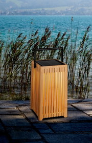 Holz-Solarleuchte mit Griff, leuchtend auf einer Terrasse am Seeufer, seitliche Perspektive