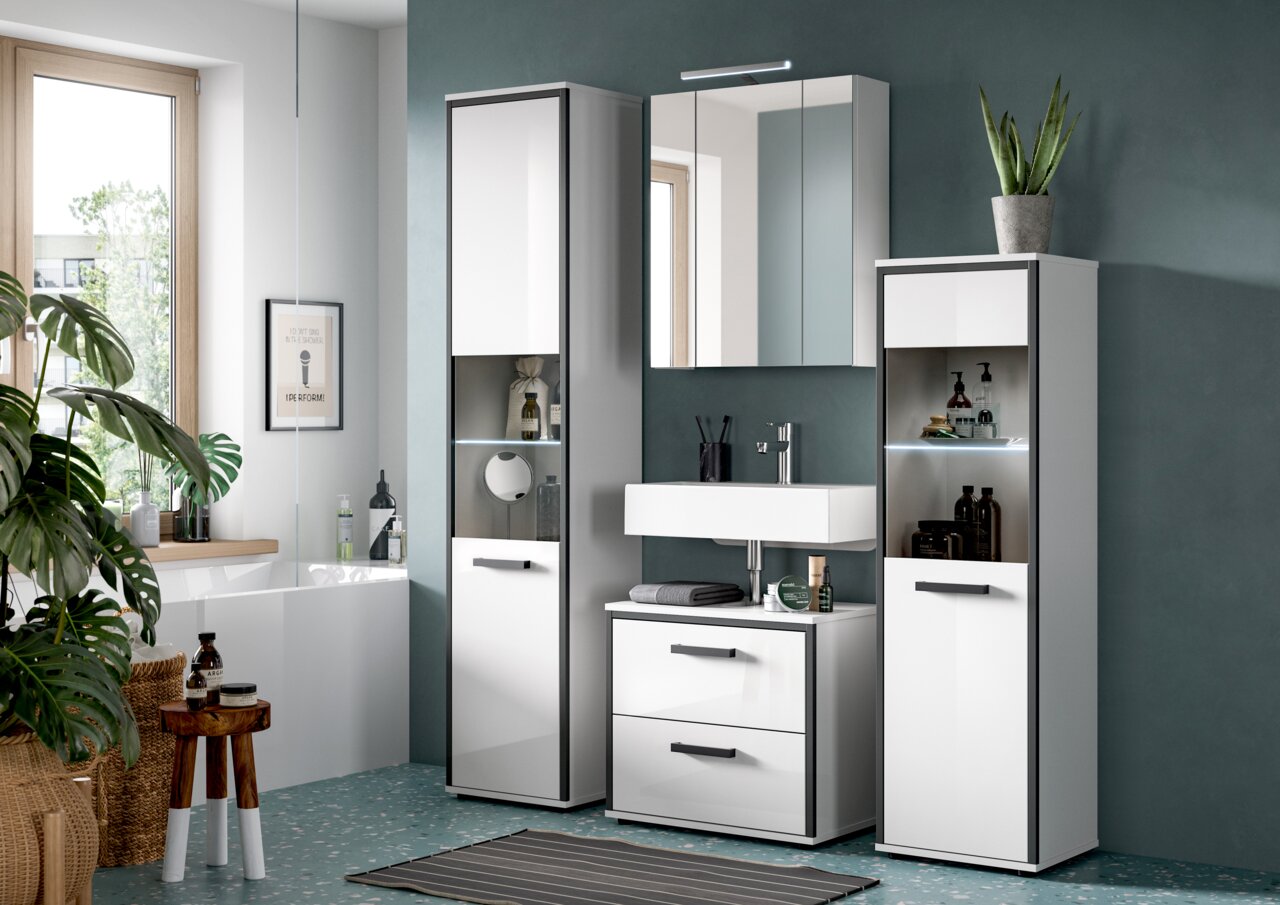 Modernes Badezimmermöbel-Set in Weiß mit schwarzen Griffen: zwei Hochschränke mit offenen, beleuchteten Regalfächern, Waschtischunterschrank mit Schubladen, wandhängender Waschtisch und Spiegelschrank; Frontansicht in leicht schräger Perspektive von links