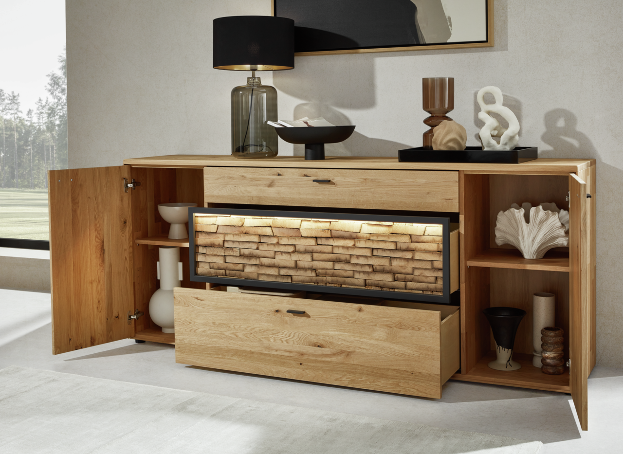 Holz-Sideboard mit geöffneter Tür und Schublade, dekoriert mit modernen Accessoires, aus frontaler Perspektive.