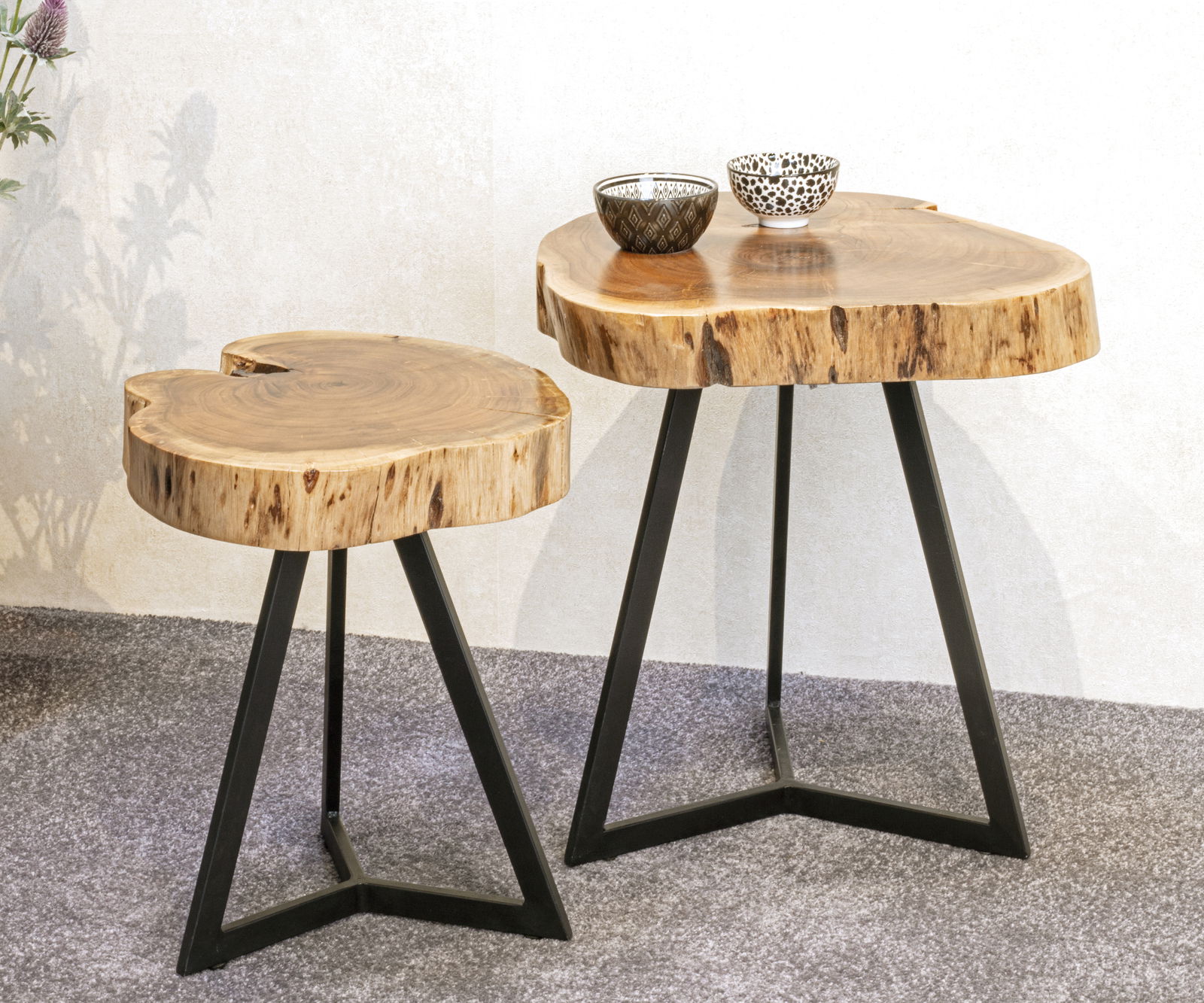 Zwei Beistelltische aus Holz mit unregelmäßiger Form und schwarzem Metallgestell, seitliche Perspektive.
