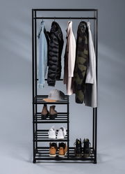 Schwarzer Garderobenwagen mit mehreren Kleiderstangen und Regalböden, frontal fotografiert, mit verschiedenen Kleidungsstücken und Schuhen.