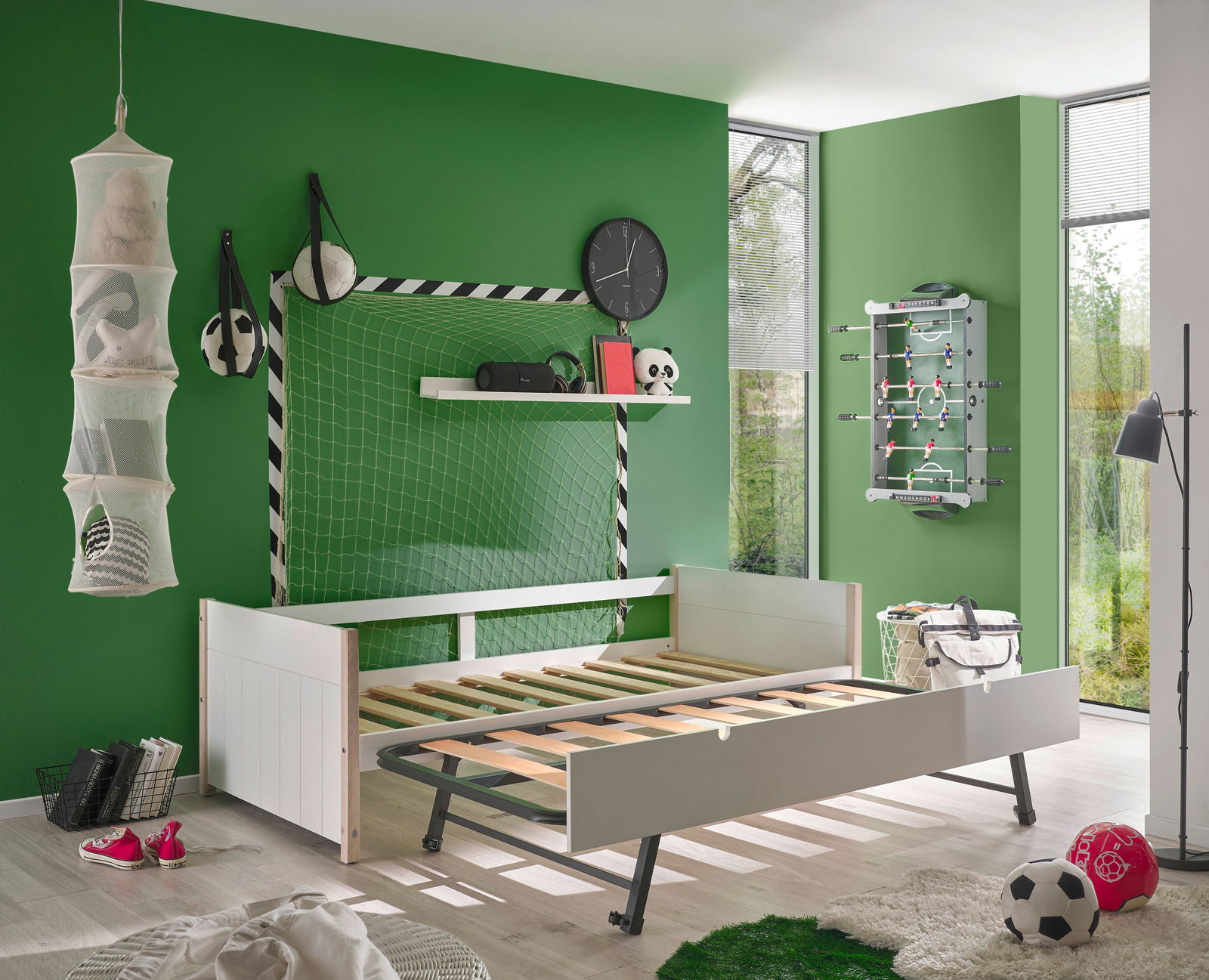 Jugendbett in einem sportlich dekorierten Zimmer mit Fußballthema, seitliche Perspektive