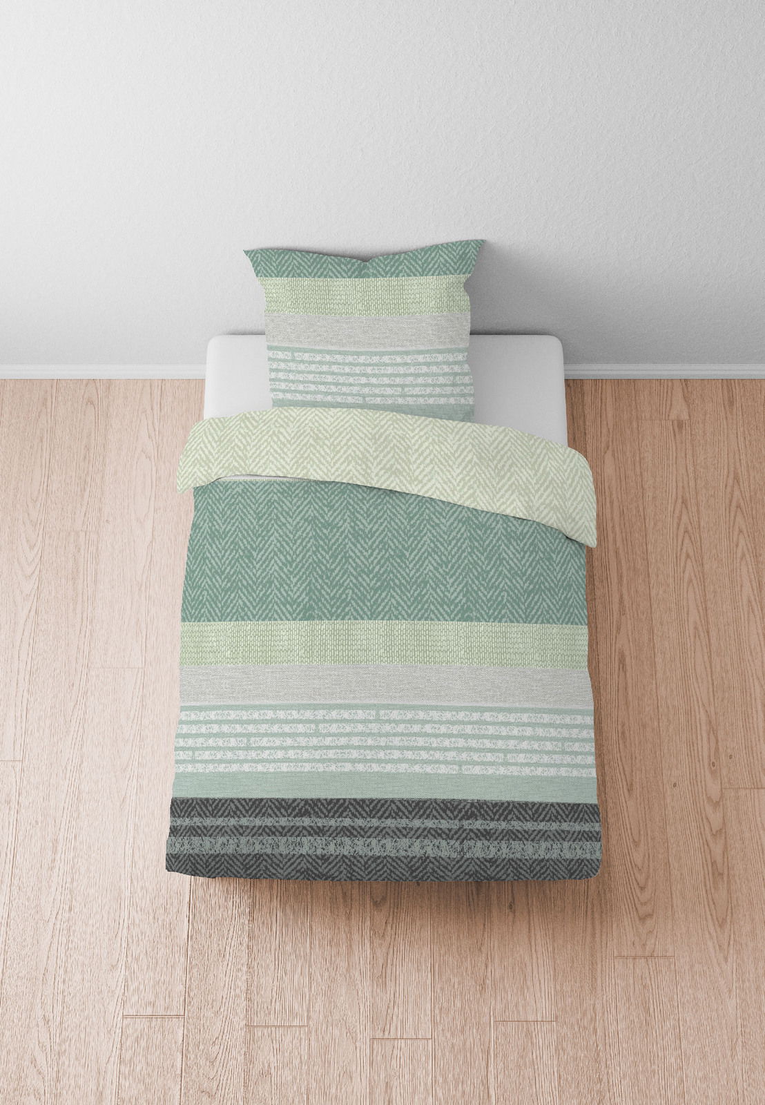 Bettwäsche-Set in Grün- und Grautönen mit geometrischen Mustern, aus der Vogelperspektive fotografiert.