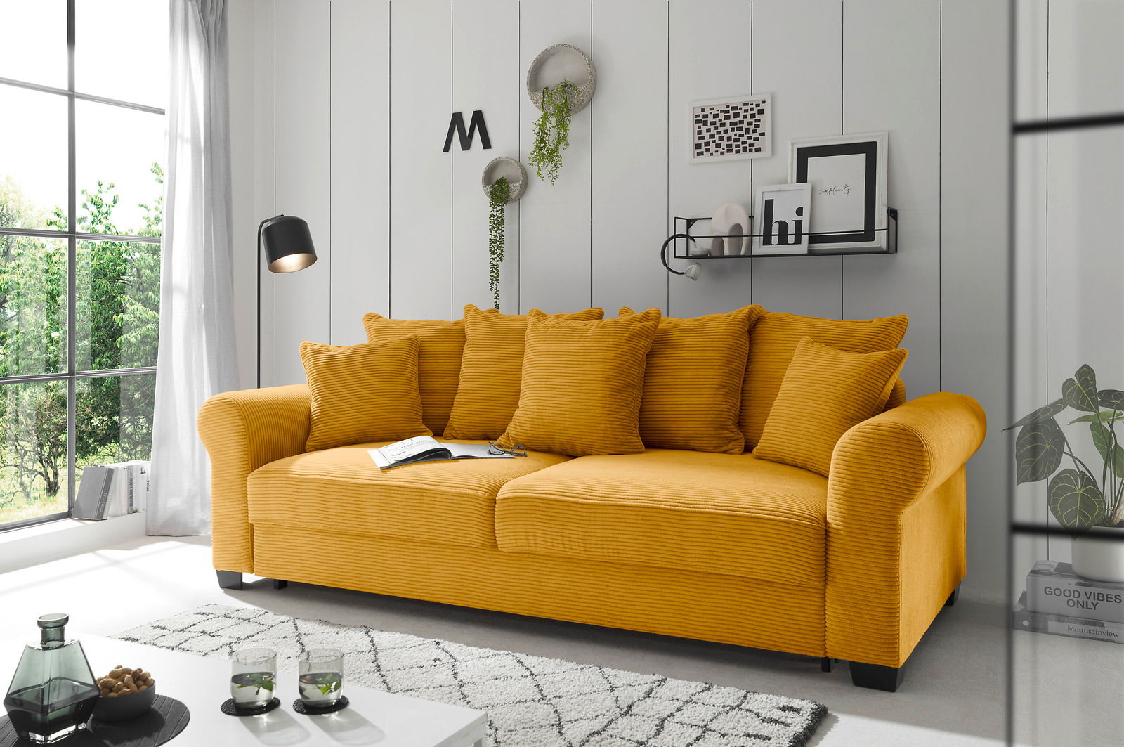 Hom´in Big Sofa MAUREEN Gelbes Funktionssofa mit mehreren Kissen in einem modernen Wohnzimmer, seitliche Perspektive.