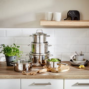 Topfset Astoria 5-tlg. aus Edelstahl, gestapelt auf einer Küchenarbeitsplatte, mit einem Topf voller grüner Bohnen im Vordergrund. Perspektive: Frontalansicht.