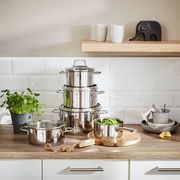 Topfset Astoria 5-tlg. aus Edelstahl, gestapelt auf einer Küchenarbeitsplatte, mit einem Topf voller grüner Bohnen im Vordergrund. Perspektive: Frontalansicht.