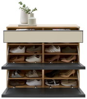 Frontalansicht eines modernen Schuhschranks aus hellem Holz mit drei nach vorn geöffneten Klappen in Schwarz und beigen Fronten, oben mit Vasen und Büchern dekoriert