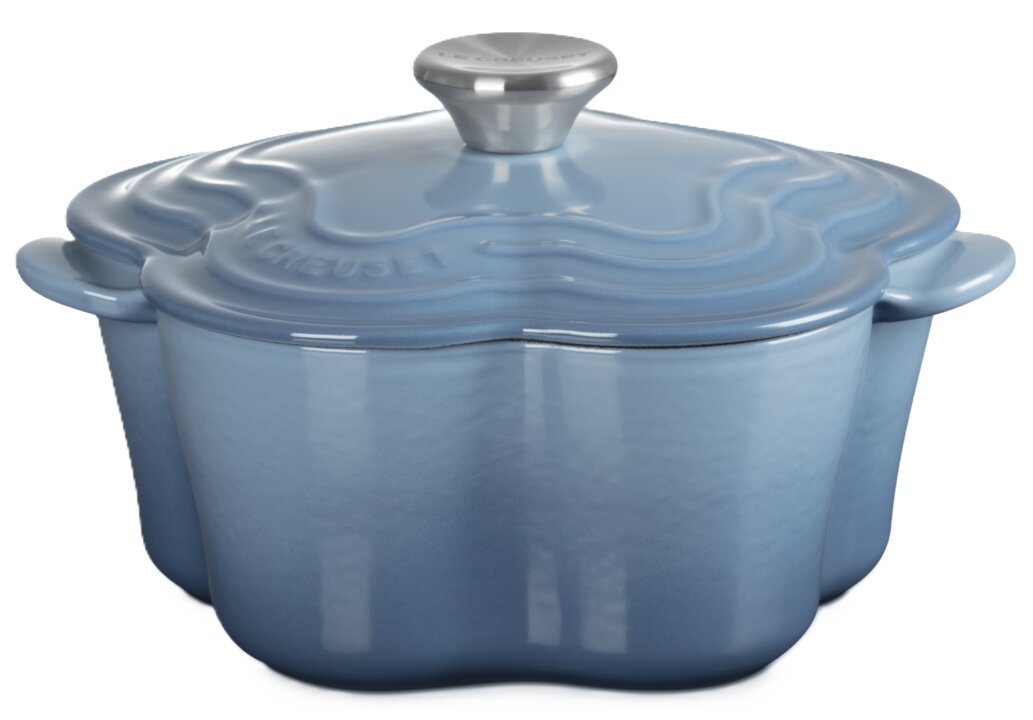 Blauer, blumenförmiger gusseiserner Schmortopf mit Deckel und silbernem Knauf, schräg von vorne in leichter Aufsicht freigestellt.