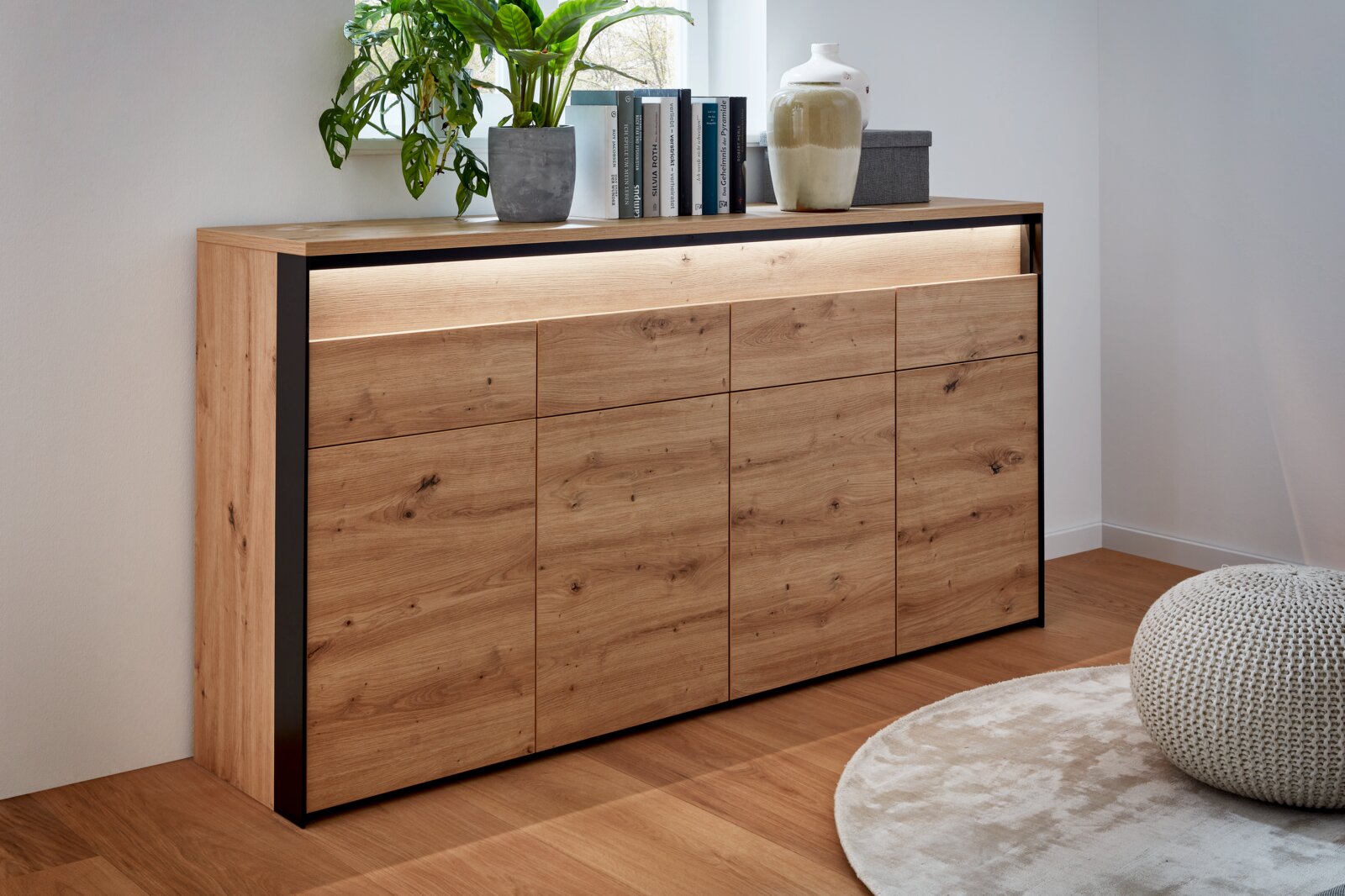 XL-Sideboard aus Holz mit moderner Optik, seitliche Perspektive, dekoriert mit Pflanzen und Büchern.