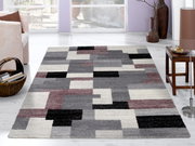 Moderner Frisé-Teppich mit geometrischem Muster in Grau-, Schwarz- und Rottönen, in einem hellen Wohnzimmer mit Blick auf den Teppich von oben.