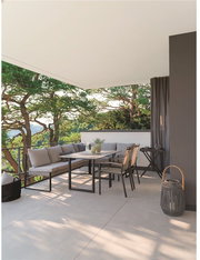 Moderne Outdoor-Lounge auf einer überdachten Terrasse mit grauem Ecksofa, Esstisch und Stühlen sowie Laterne, seitliche Perspektive