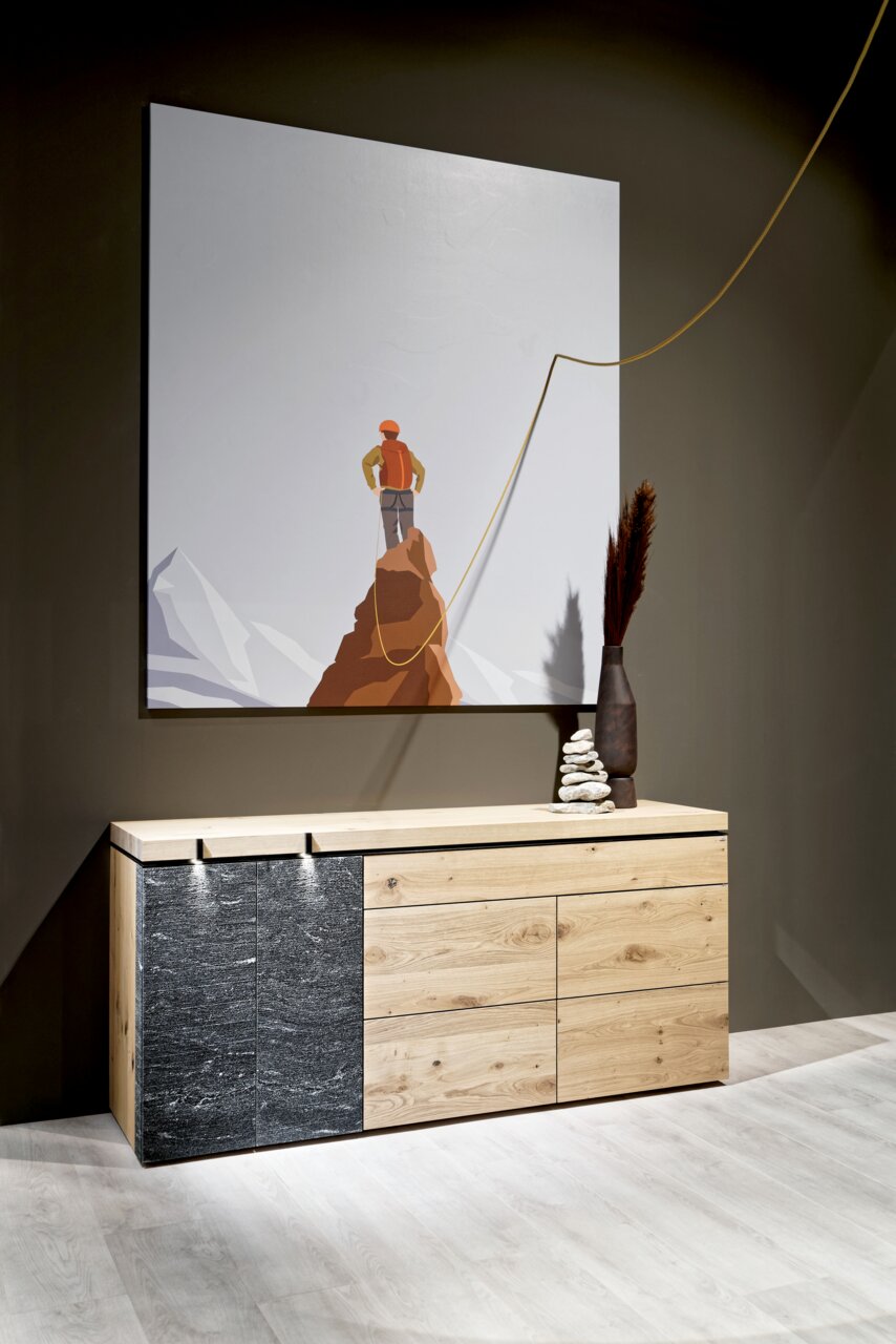 Voglauer Sideboard V-ROCK Modernes Sideboard aus Holz und Stein mit künstlerischem Bild im Hintergrund, seitliche Perspektive.