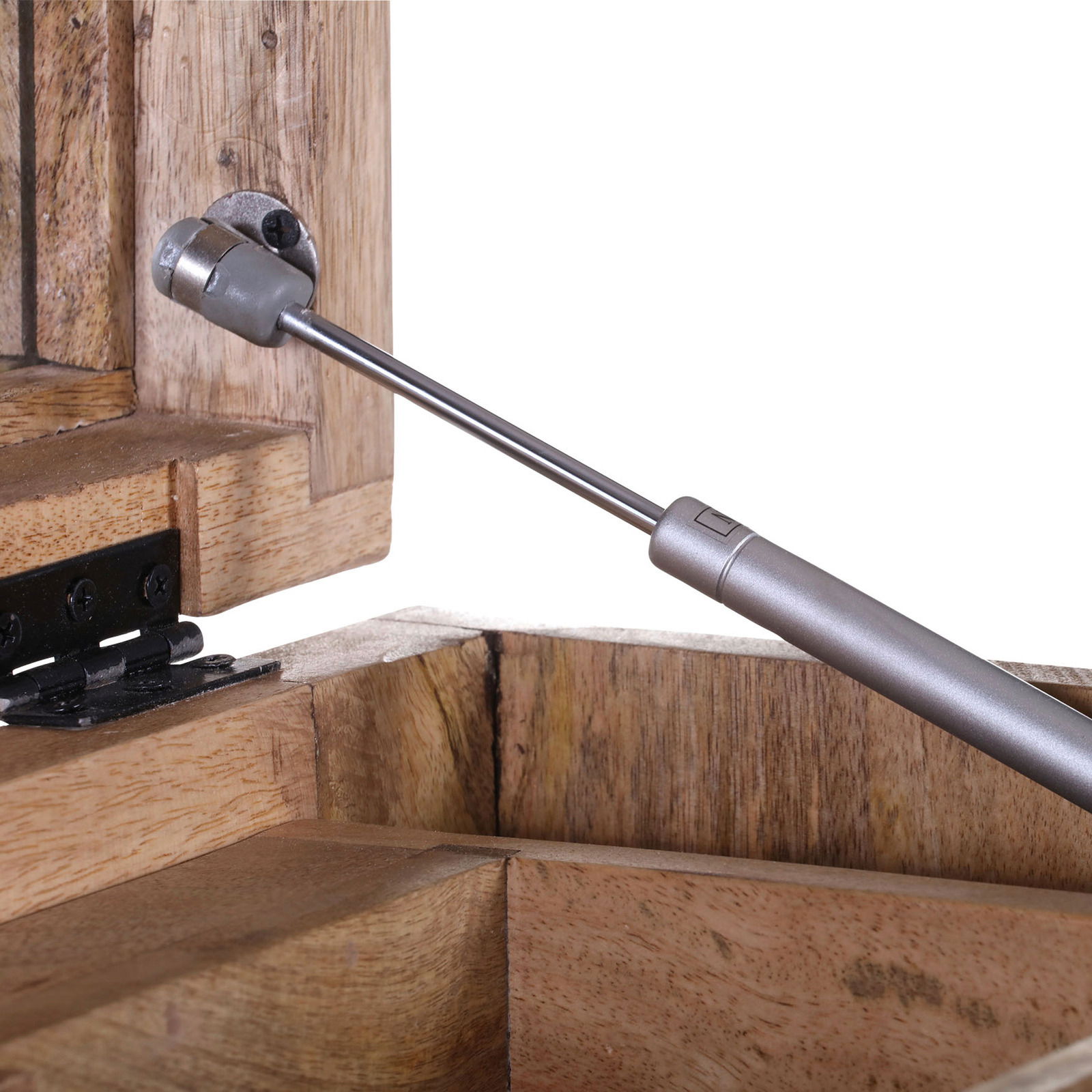 Nahaufnahme eines Scharniers und einer Gasdruckfeder an einer Schubkastenkommode aus Holz, seitliche Perspektive.