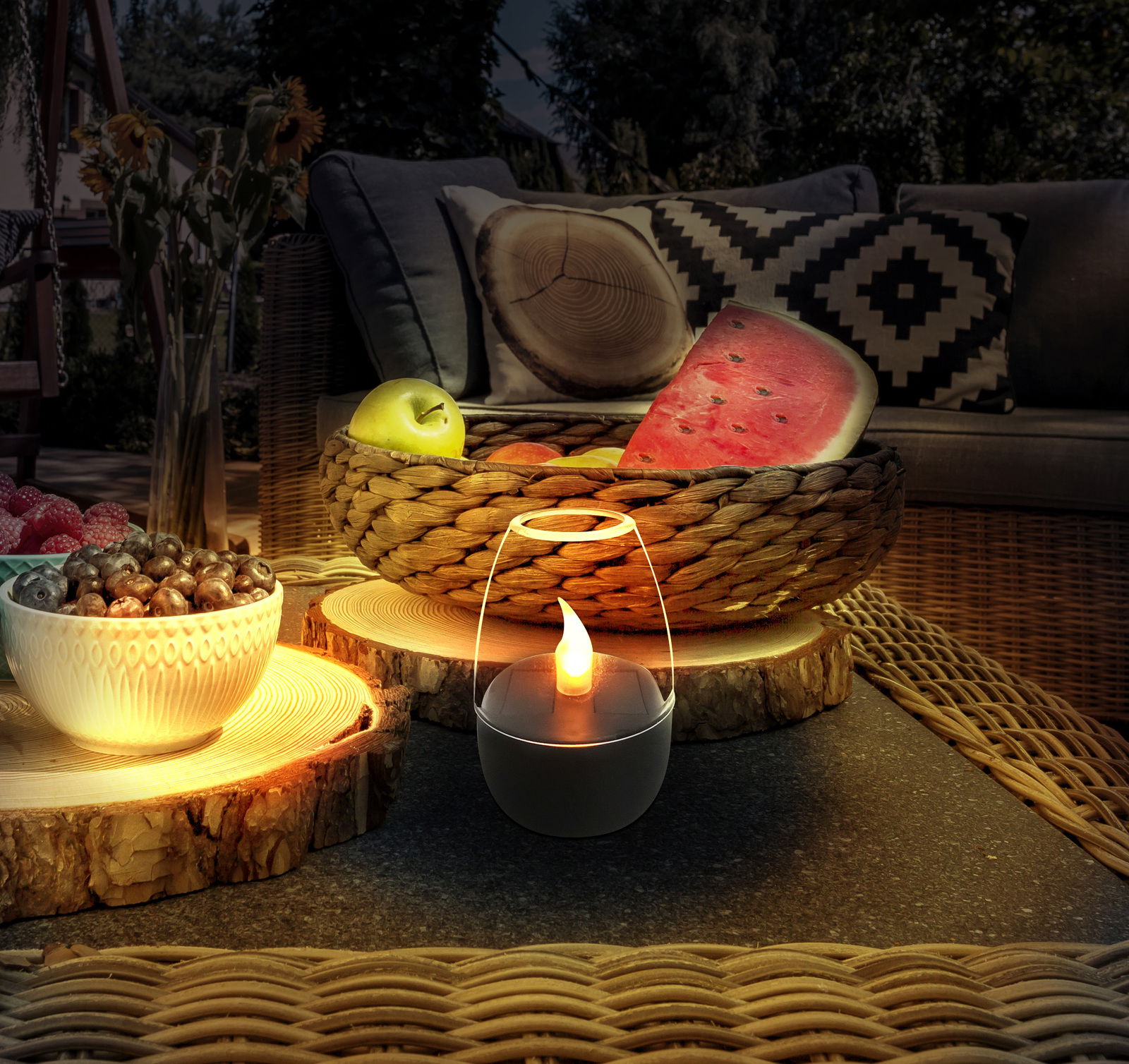 Stimmungsvolle Solarleuchte in einem gemütlichen Gartenambiente, beleuchtet von einer warmen Flamme, umgeben von Obst und dekorativen Elementen auf einem Tisch aus Holz.