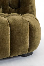 Nahaufnahme einer olivgrünen Couch mit weichem, gepolstertem Stoff und abgerundeten Formen, seitliche Perspektive.