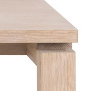 Nahaufnahme eines Esstischs aus hellem Holz, Perspektive von der Ecke