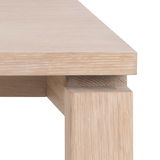 Nahaufnahme eines Esstischs aus hellem Holz, Perspektive von der Ecke