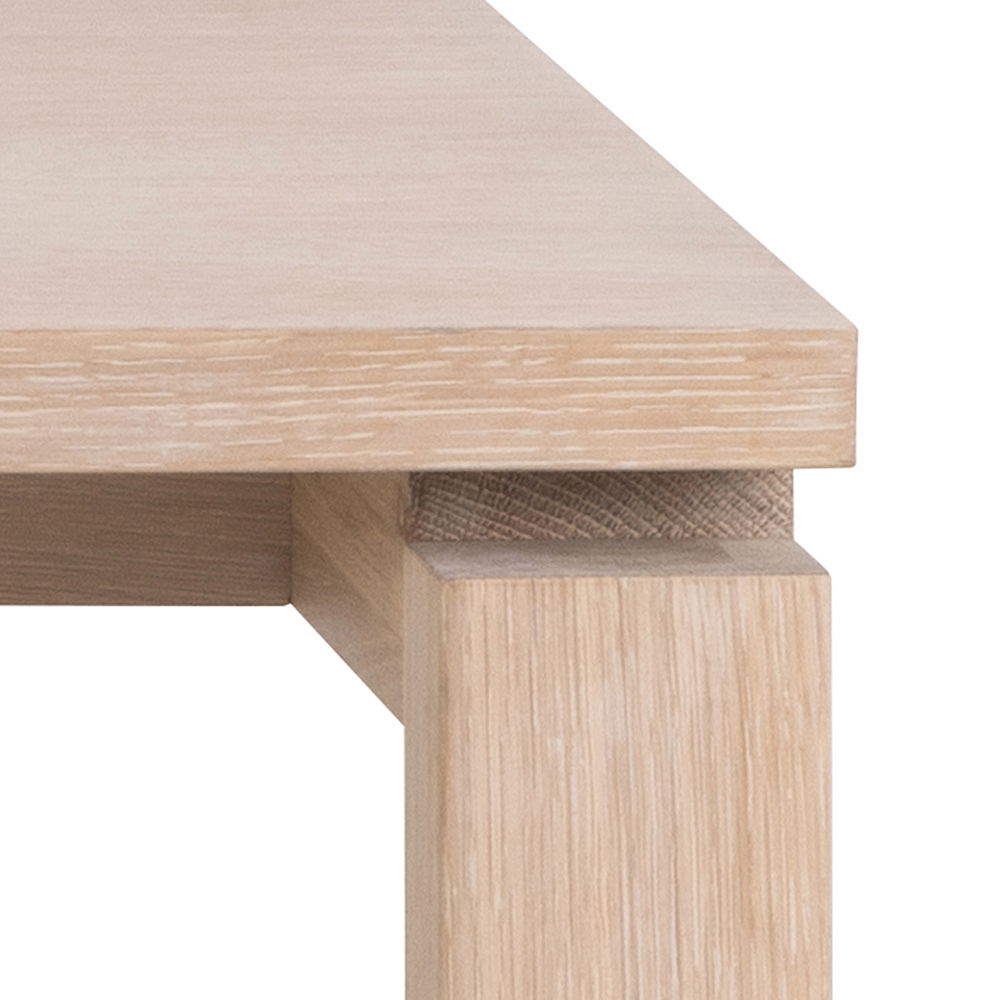 Nahaufnahme eines Esstischs aus hellem Holz, Perspektive von der Ecke