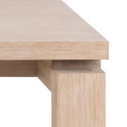 Nahaufnahme eines Esstischs aus hellem Holz, Perspektive von der Ecke
