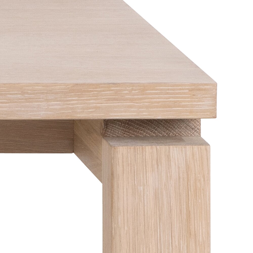 Nahaufnahme eines Esstischs aus hellem Holz, Perspektive von der Ecke