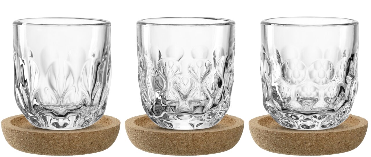 Leonardo Espresso-Set 6-tlg. GOCCE Drei elegante, durchsichtige Espressogläser mit strukturierter Oberfläche, präsentiert auf runden Korkuntersetzern, Frontalansicht.