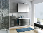 Modernes Badezimmer mit grauem Badblock, bestehend aus einem Waschbecken mit Unterschrank und einem Hängeschrank, seitliche Perspektive.