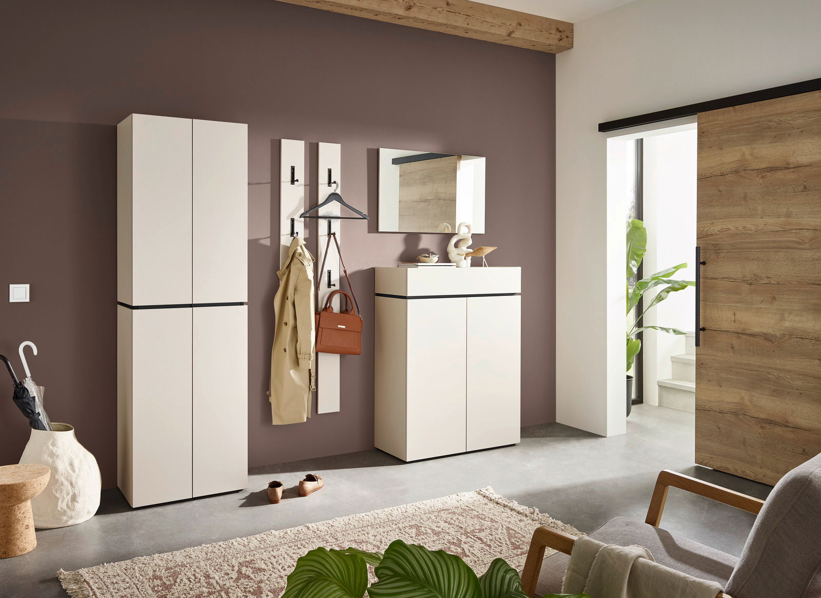 Moderner Eingangsbereich mit Garderobenmöbeln in heller Farbe, bestehend aus Schuhschrank, Garderobenpaneel und Spiegel, seitliche Perspektive.