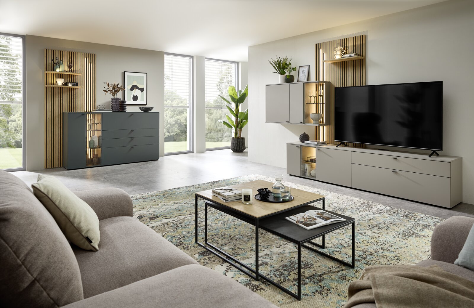 Moderne Wohnzimmeransicht mit Sideboardkombination, bestehend aus einem grauen Sideboard und einem TV-Schrank, dekoriert mit Pflanzen und Kunstwerken, aus der Perspektive eines gemütlichen Sofas.