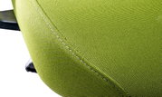 Close-up van een groene stoffen bekleding van een draaistoel, zijaanzicht