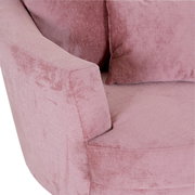 Nahaufnahme eines rosa Sessels mit weicher Polsterung und Kissen, seitliche Perspektive