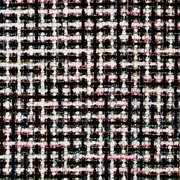 Nahaufnahme eines mehrfarbigen, strukturierten Stoffmusters mit schwarzem, weißem, rosa und blauem Karodesign, von oben betrachtet.