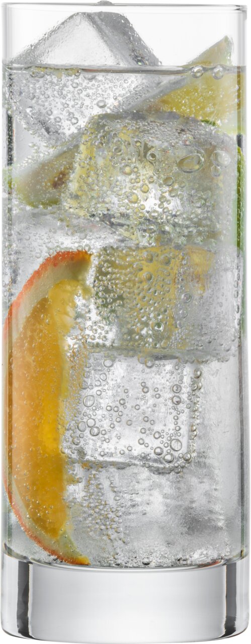 Ein Longdrinkglas Tavoro, gefüllt mit einem sprudelnden Getränk, Eiswürfeln und Zitrusfrüchten, aus der Seitenperspektive fotografiert.