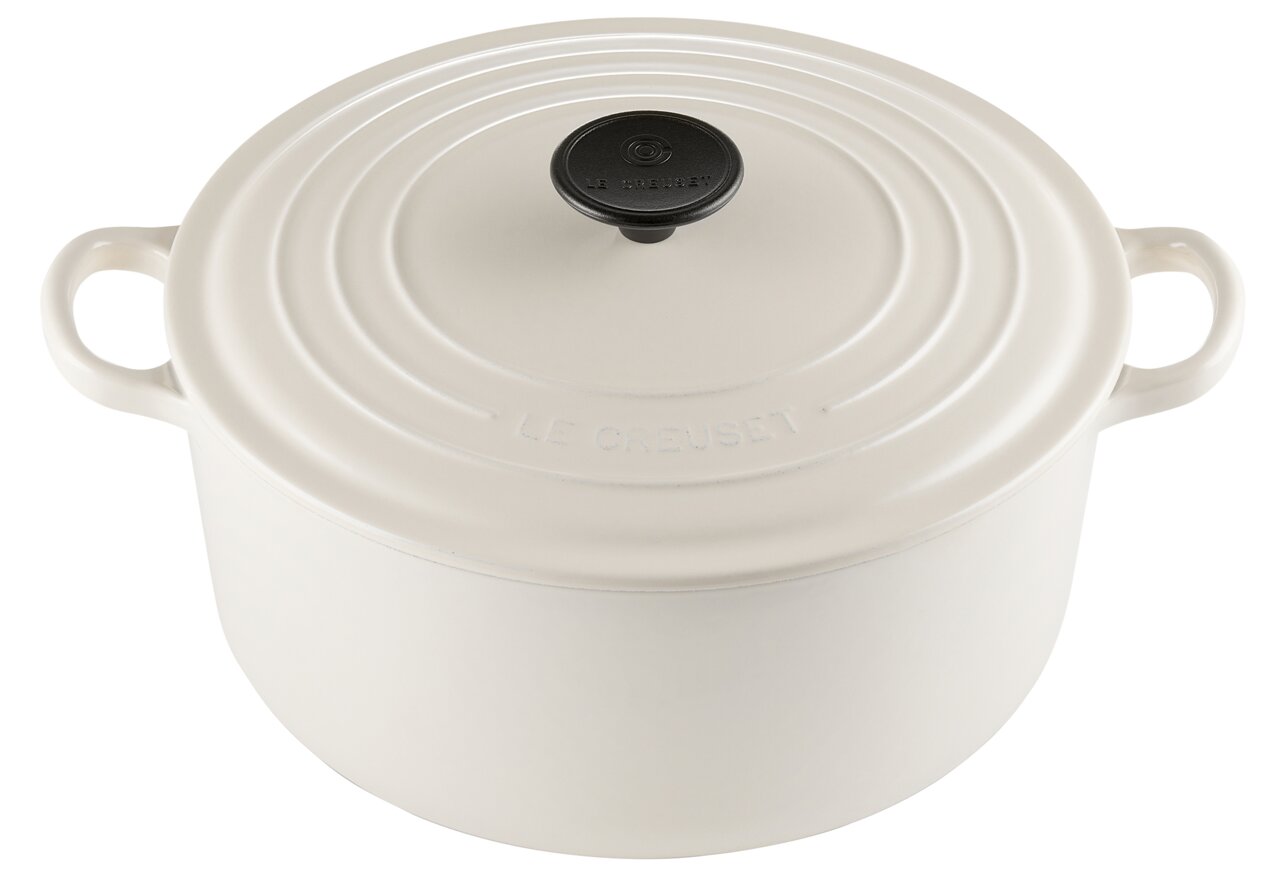 Cremefarbener Bräter von Le Creuset mit Deckel, aus der Vogelperspektive fotografiert.
