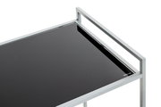 Nahaufnahme eines modernen Servierwagens mit silbernem Metallrahmen und schwarzer Glasablage (gehärtetes Glas), schräg von oben aus der Ecke fotografiert