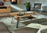 Moderner Couchtisch aus Holz mit schwarzem Metallgestell, dekoriert mit Büchern und Keramikfiguren, in einem stilvollen Wohnzimmer. Perspektive von der Seite.