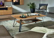Moderner Couchtisch aus Holz mit schwarzem Metallgestell, dekoriert mit Büchern und Keramikfiguren, in einem stilvollen Wohnzimmer. Perspektive von der Seite.