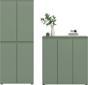 Salbeigrünes, minimalistisches Schrank-Set mit glatten Fronten: links ein hoher zweitüriger Schrank, rechts ein niedriges Sideboard mit drei Türen; auf dem Sideboard Vase mit grünen Zweigen und Bücherstapel, Frontansicht.