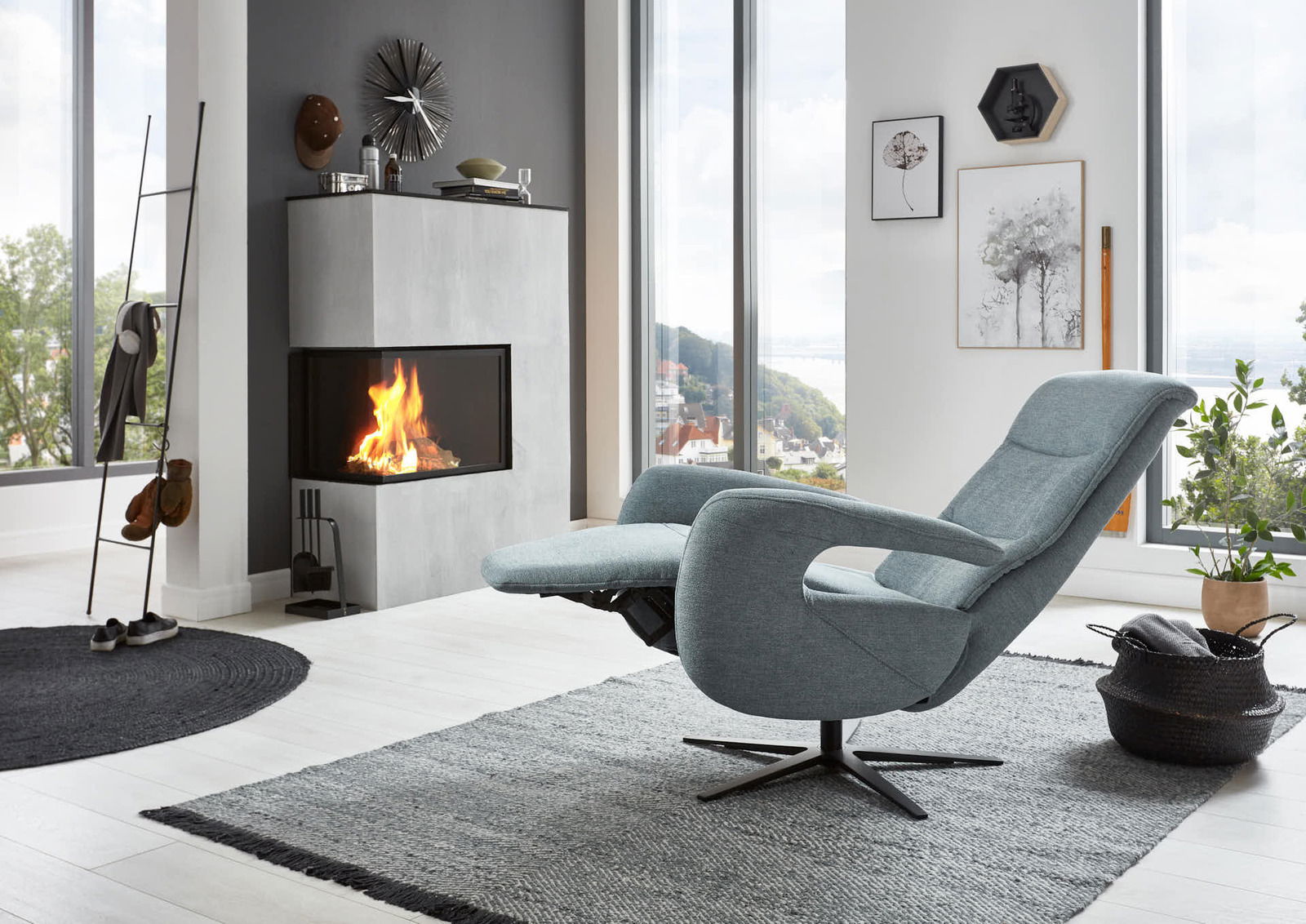 Moderner Relaxsessel in einem stilvollen Wohnzimmer mit Blick auf einen Kamin und große Fenster, seitliche Perspektive.