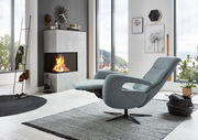 Moderner Relaxsessel in einem stilvollen Wohnzimmer mit Blick auf einen Kamin und große Fenster, seitliche Perspektive.