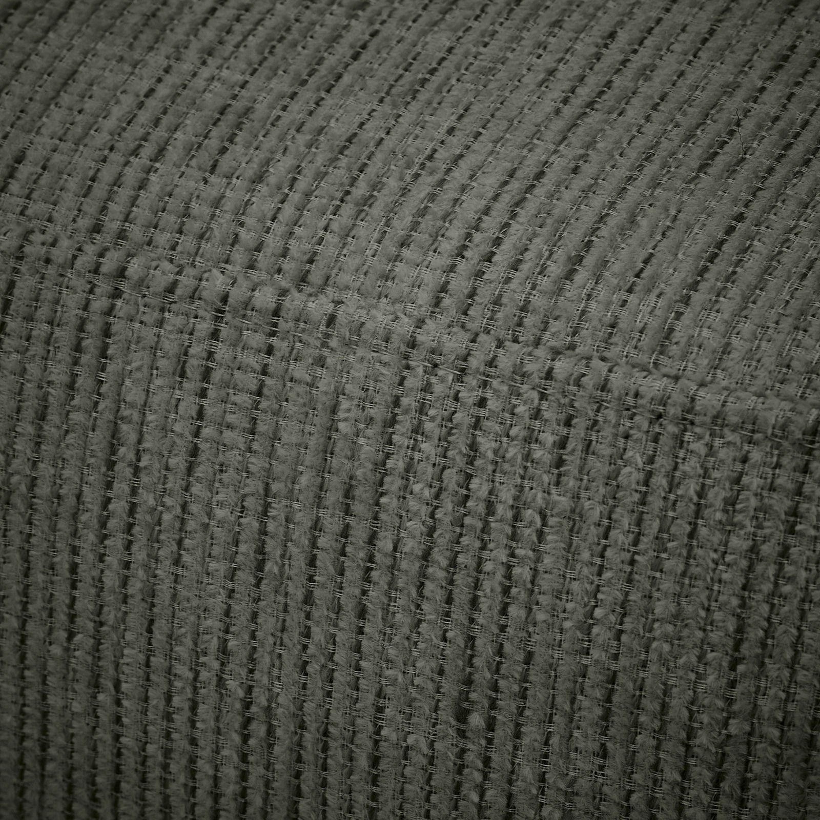 Nahaufnahme eines strukturierten Stoffes in dunklem Grün, perspektivisch von oben betrachtet.