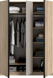 Offener Kleiderschrank in heller Holzoptik mit mittlerer Tür, links Kleiderstange mit hängender Kleidung und Ablagefächern, rechts mehrere Regalböden mit gefalteten Textilien und Hut, Frontansicht.