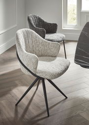 Zwei moderne Armlehnstühle mit Stoffbezug in hellen und dunklen Grautönen, auf einem Holzfußboden in einem hellen Raum, aus seitlicher Perspektive fotografiert.