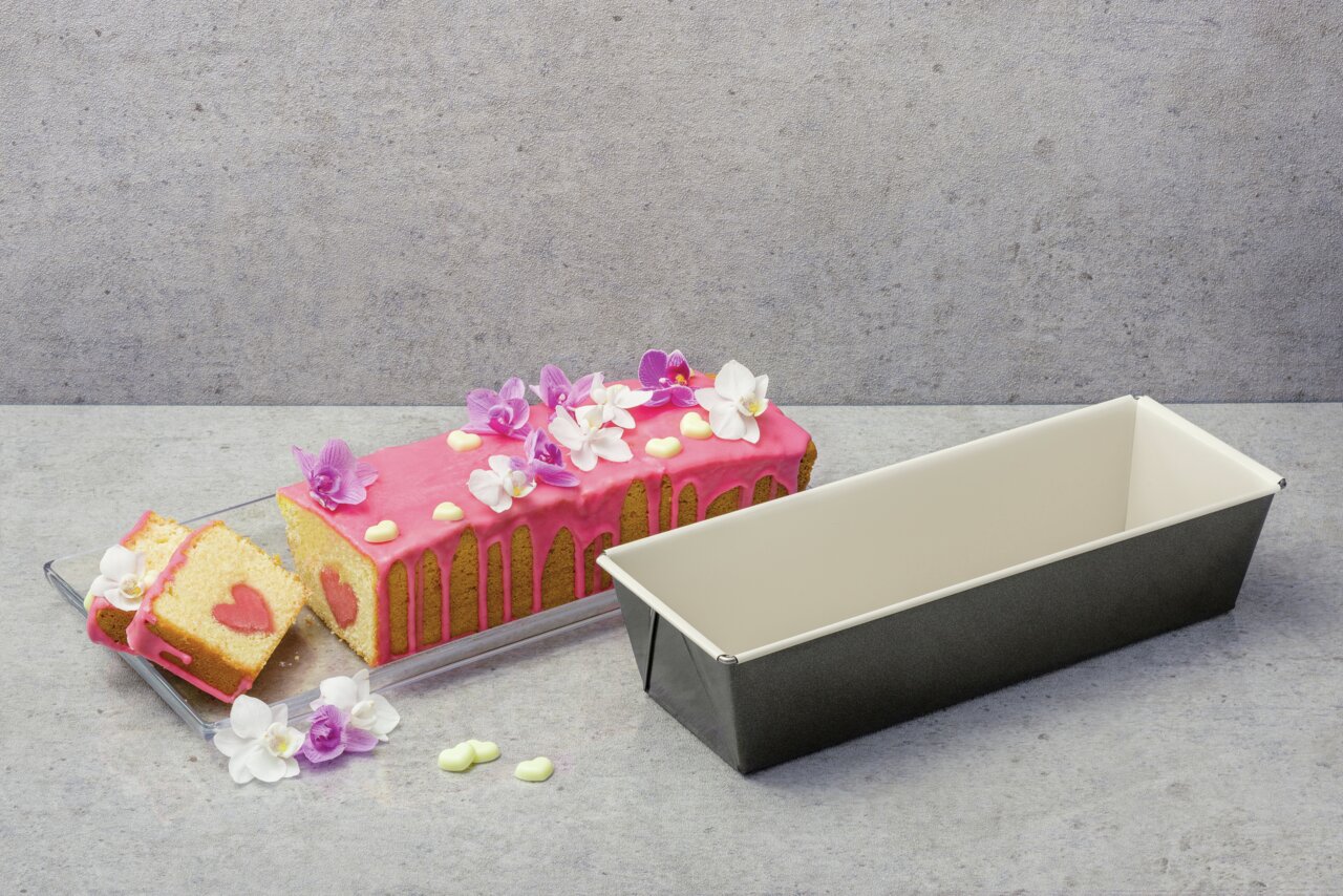 Kastenform 30 cm BackTrend mit gebackenem Kuchen, dekoriert mit rosa Glasur und Blumen, seitliche Perspektive