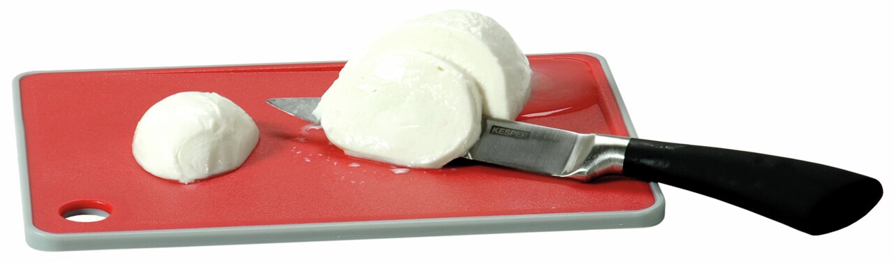 Homeware Schneidebrett mit Rutsch Stop Rotes Schneidebrett mit grauem Rand, darauf ein Messer und geschnittene Mozzarella-Kugeln, aus der Vogelperspektive.