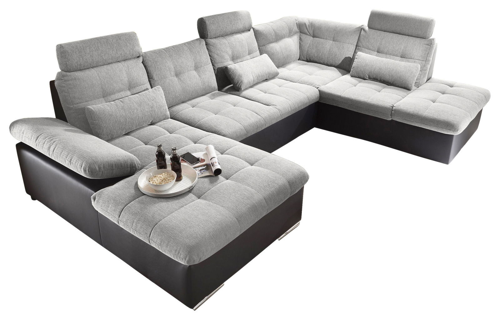 Großes, modernes Ecksofa in U-Form mit grauem Stoffbezug und schwarzen Lederakzenten, aus der Vogelperspektive fotografiert.