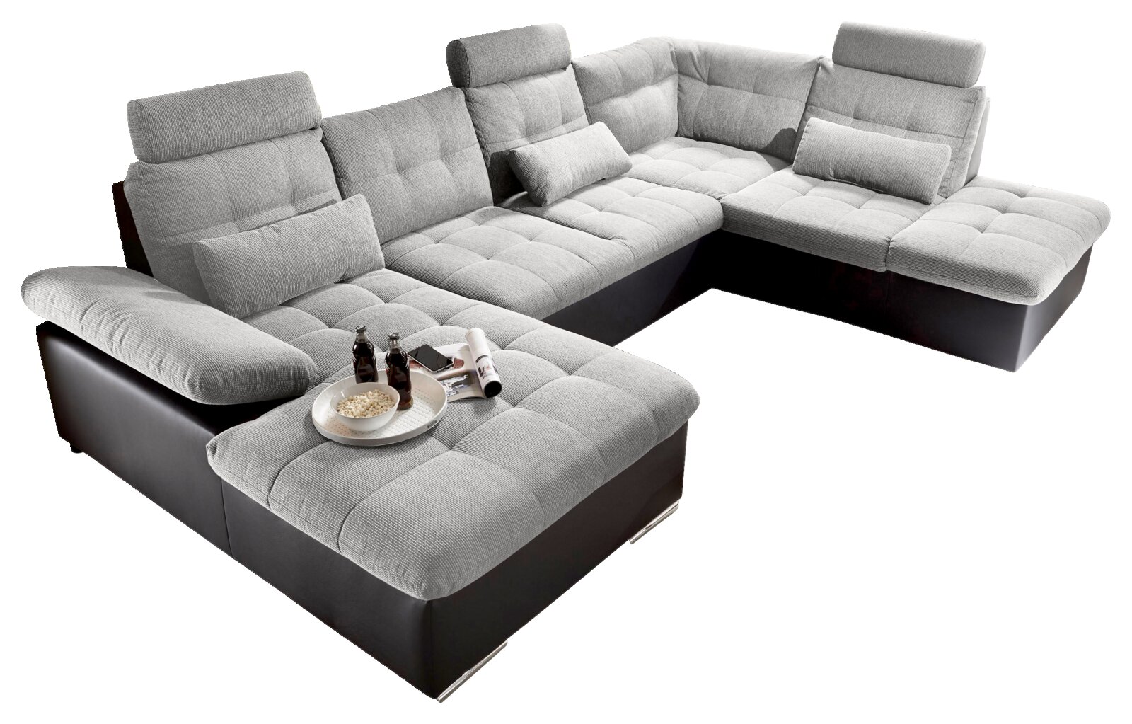 Großes, modernes Ecksofa in U-Form mit grauem Stoffbezug und schwarzen Lederakzenten, aus der Vogelperspektive fotografiert.
