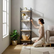 Modernes Standregal mit schwarzem Metallrahmen und Holzablagen im Wohnzimmer, dekoriert mit Lampe, Büchern, Pflanze und Korb; Perspektive: frontale, leicht seitliche Aufnahme auf Augenhöhe.